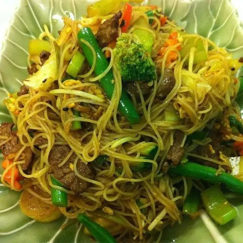 A Plate Of Noodles With Meat And Vegetables On A Table — One Thai Cuisine & Noodle Bar In Kirwan, QLD