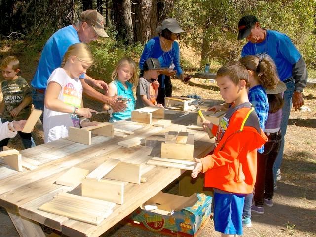 A group of children are working on a wooden table