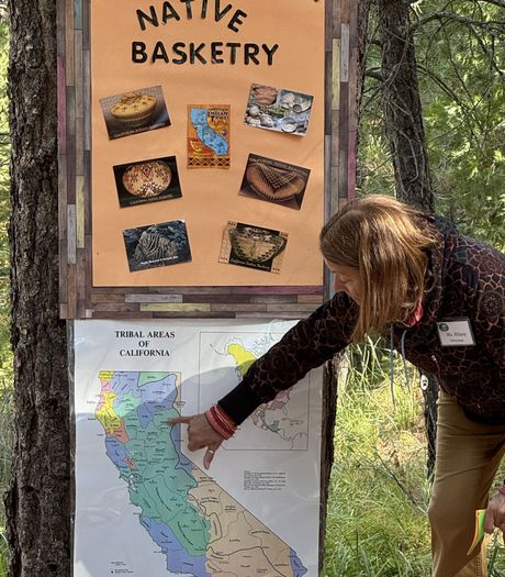 A woman is pointing at a sign that says native basketry