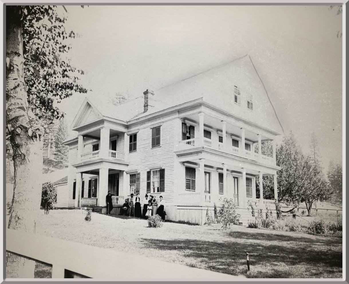 A black and white photo of a large white house
