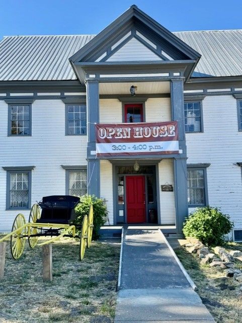 A white building with a sign that says open house