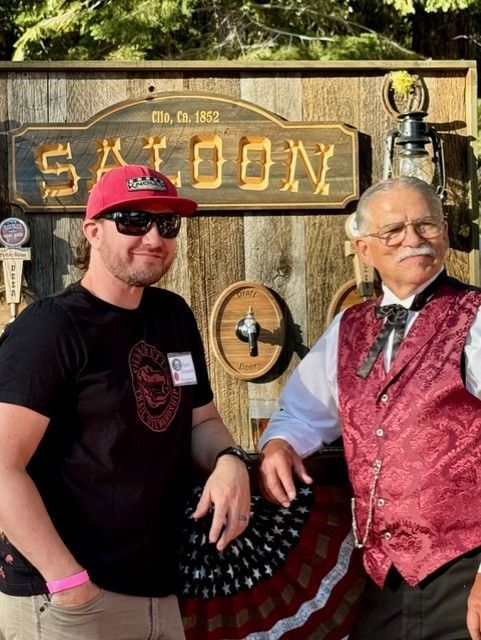 Two men standing in front of a saloon sign
