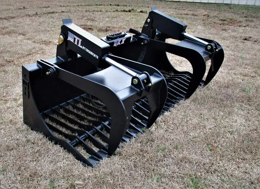 Black industrial skid-steer attachment with angled side wings and yellow warning labels