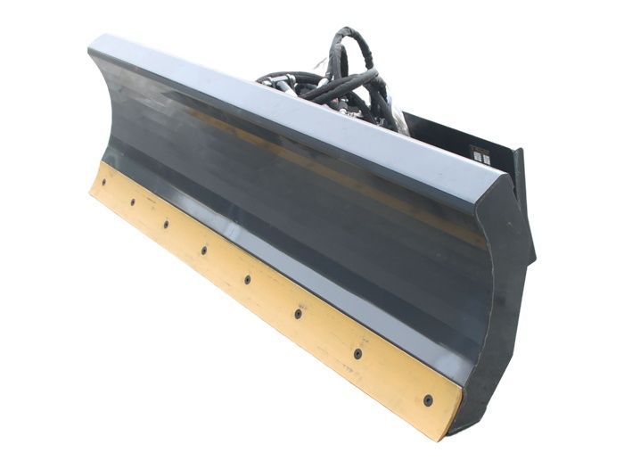 Black skid steer loader dumping orange wood chips from its bucket on a white background