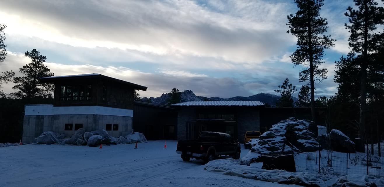 A snowy driveway with a house in the background