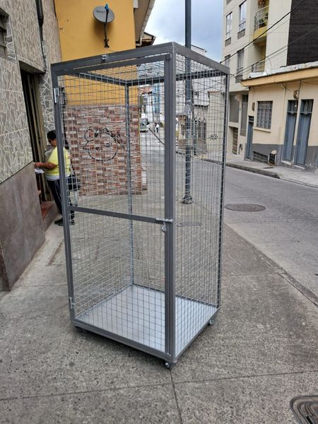 Técnico instalando malla eslabonada galvanizada en una vivienda con postes metálicos.