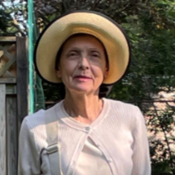 Une femme portant un chapeau et un pull blanc