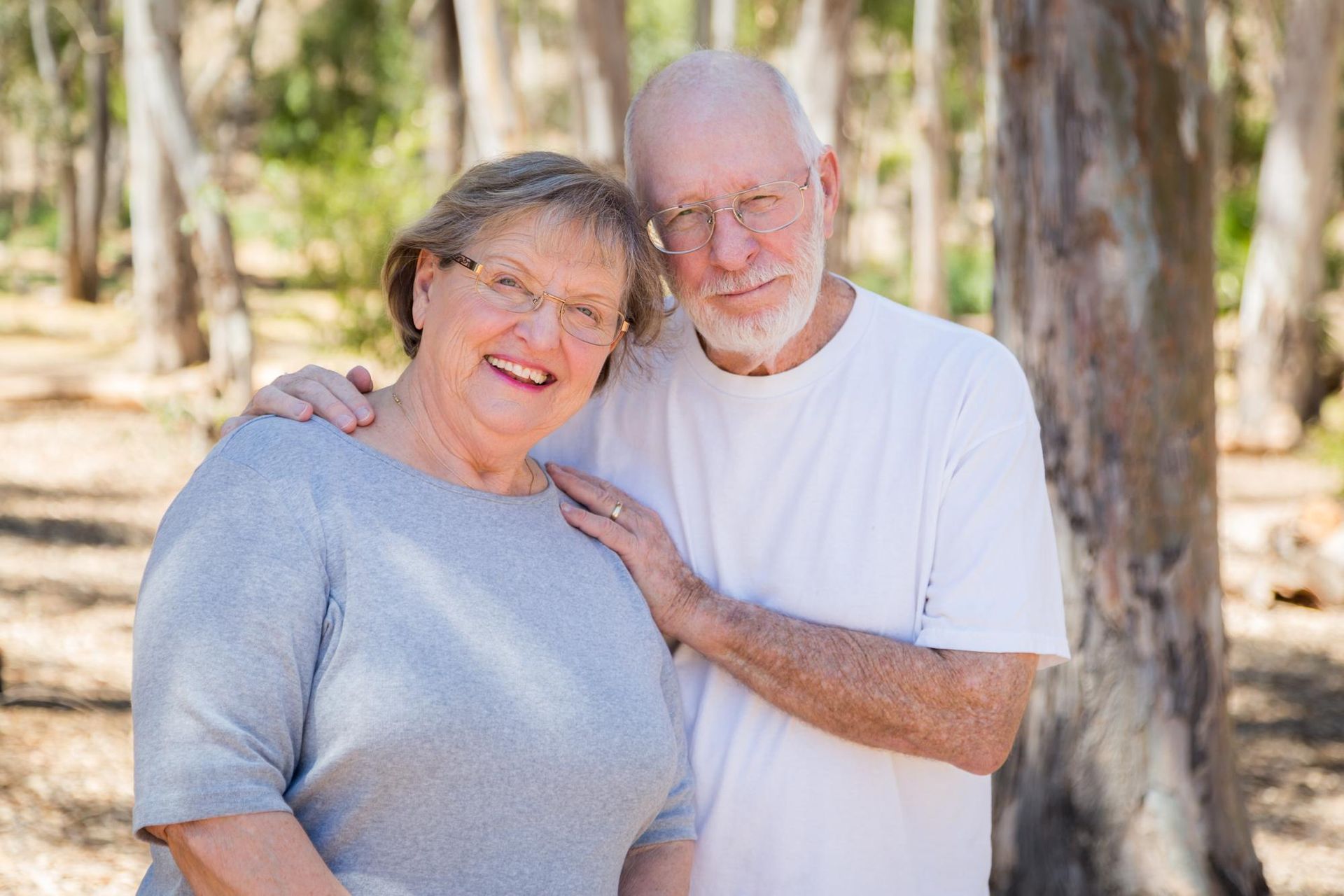 A smiling couple in the outdoors, representing life insurance for seniors and retirement planning options.