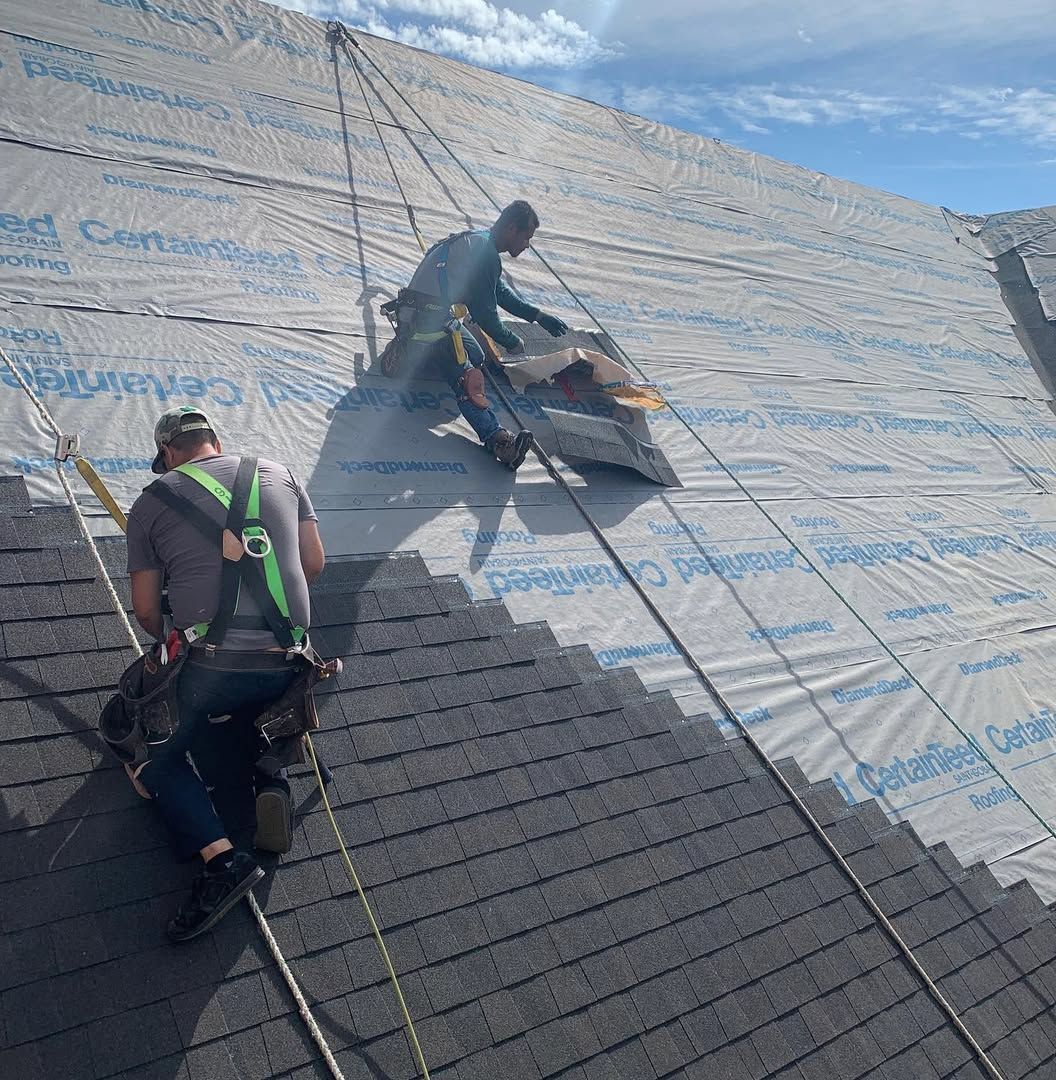 Two men are working on the roof of a building.
