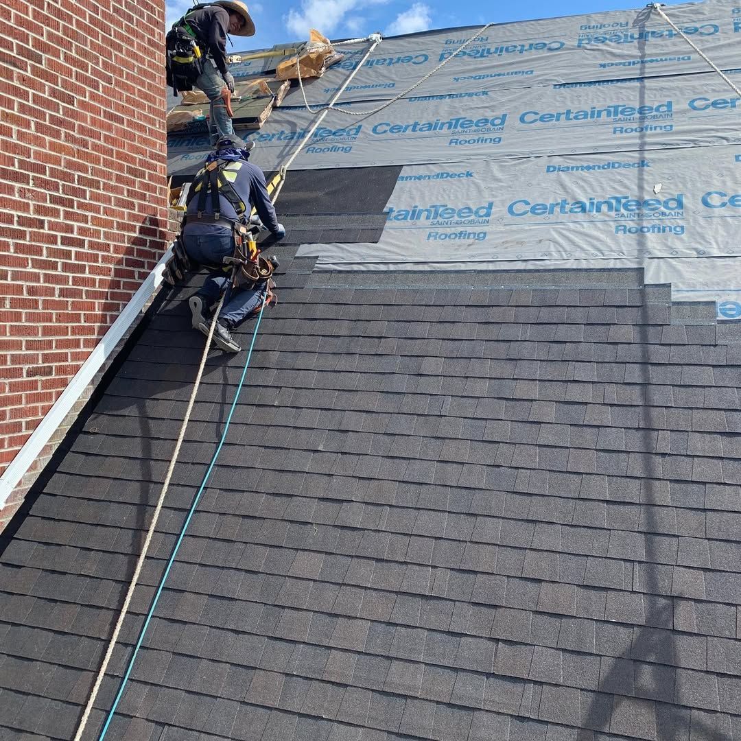 A man is climbing up a roof with a rope.