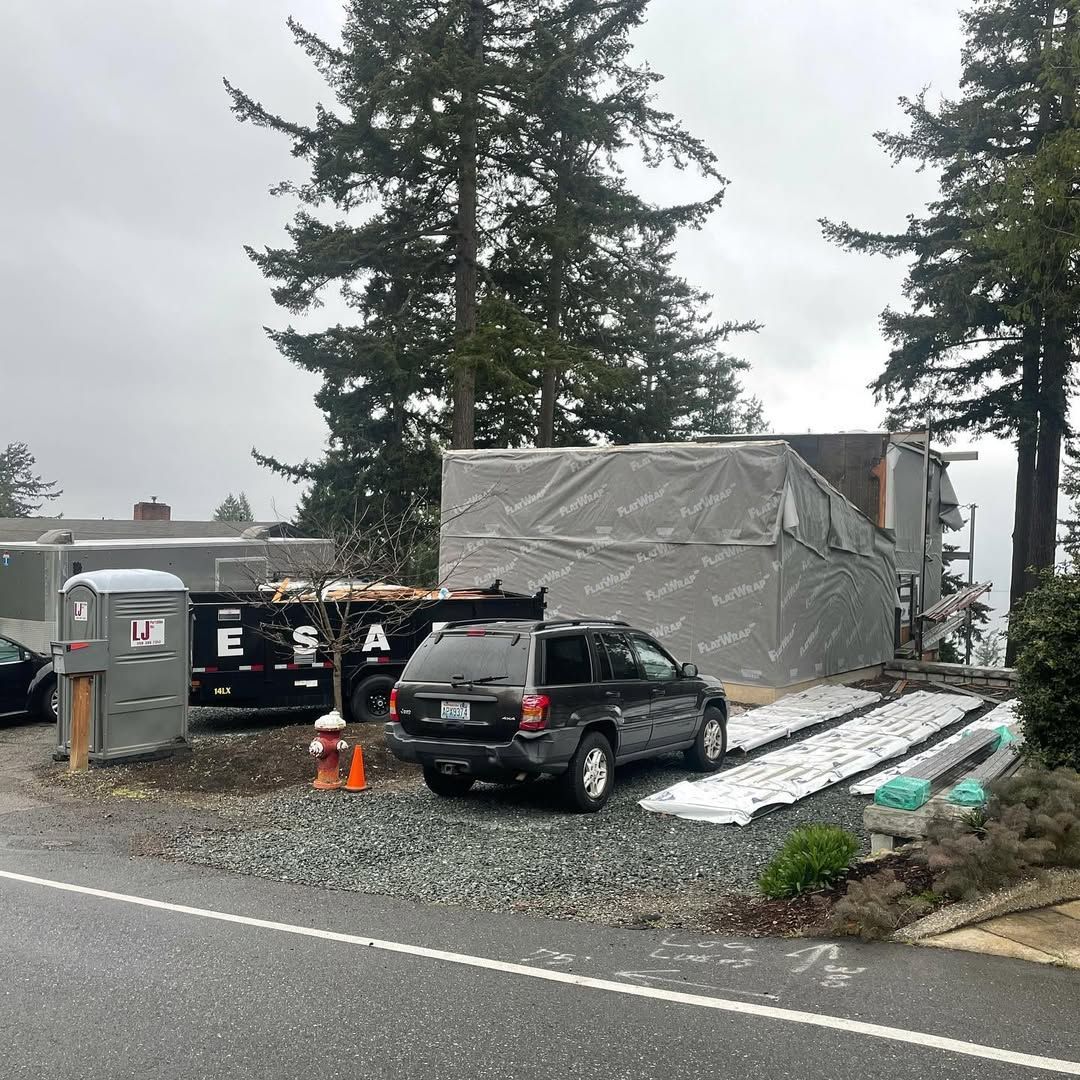 A car is parked on the side of the road next to a dumpster.