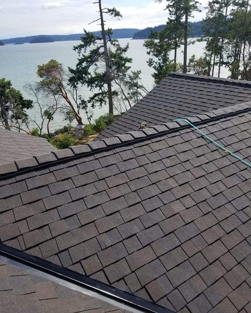 A roof with a view of a lake and trees.