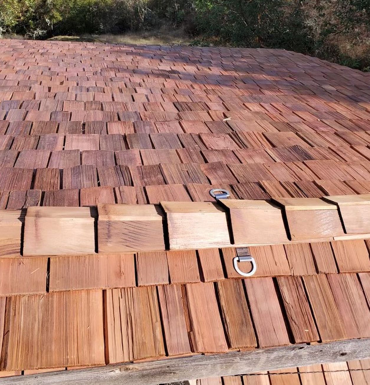 A close up of a roof with wood shake shingles on it.