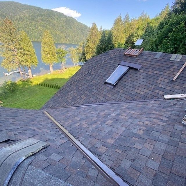 A roof with a skylight and a lake in the background