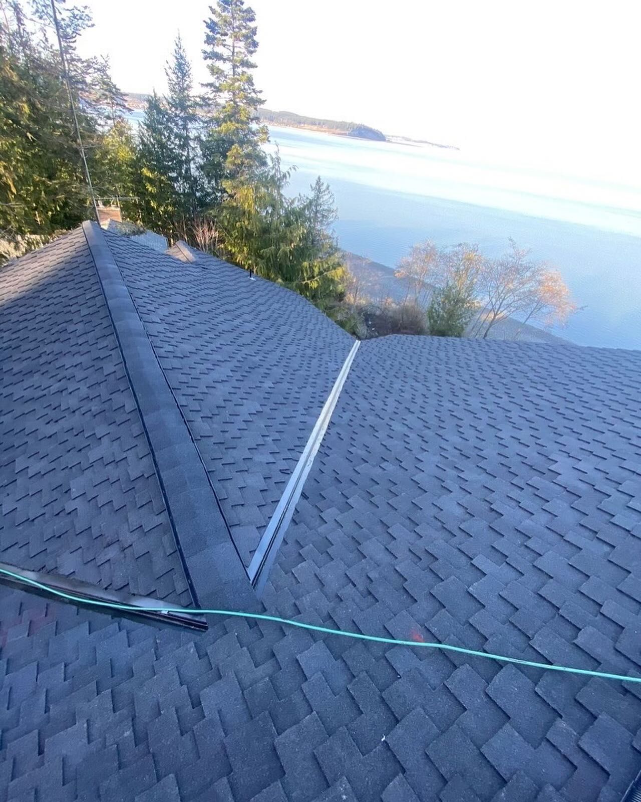 A roof with a view of a body of water and trees