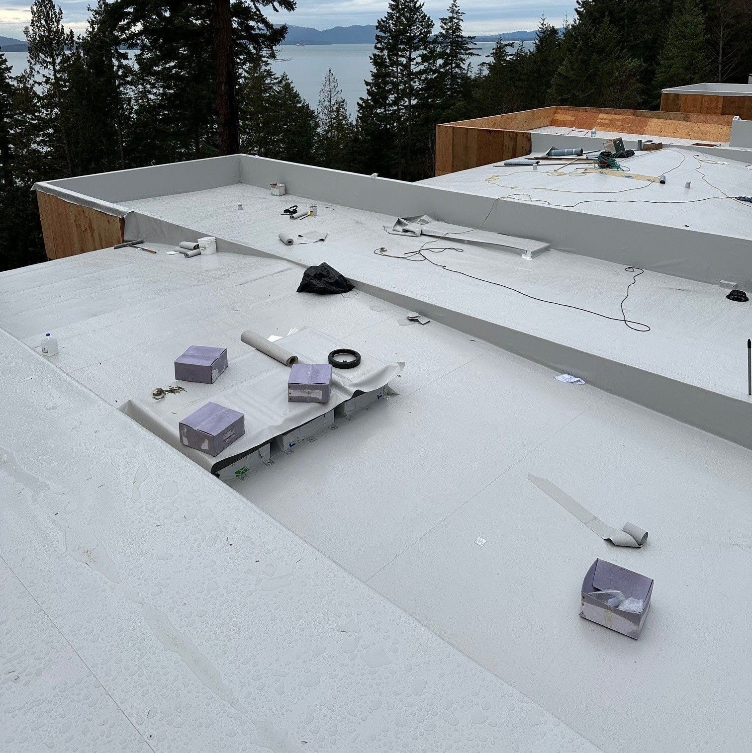 A white flat roof roof with boxes on it and trees in the background