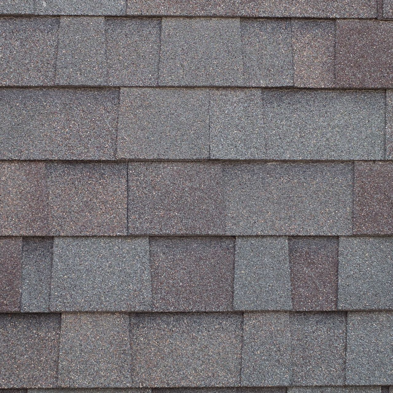 A close up of a roof with composite shingles on it