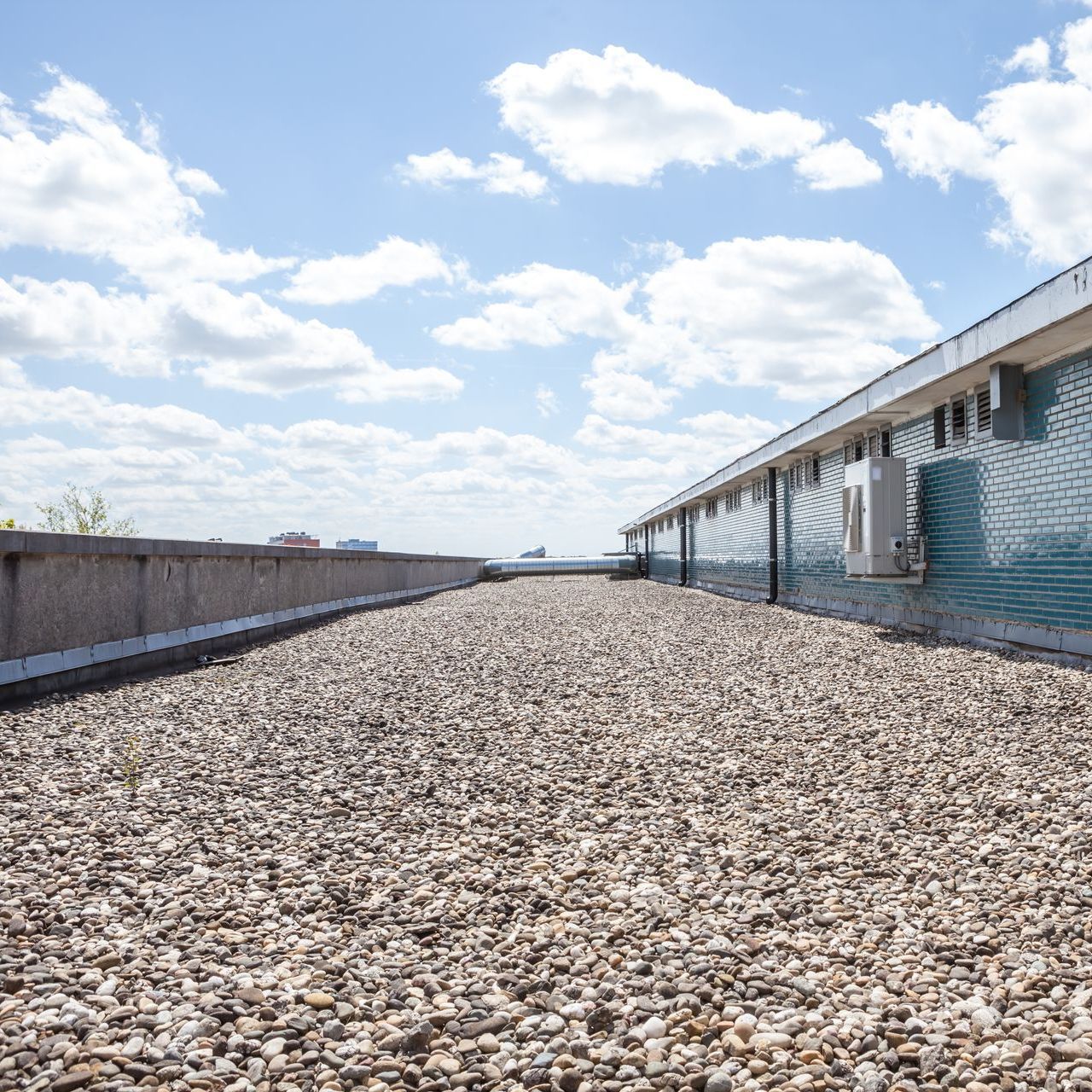 A pile of gravel is on the roof of a building