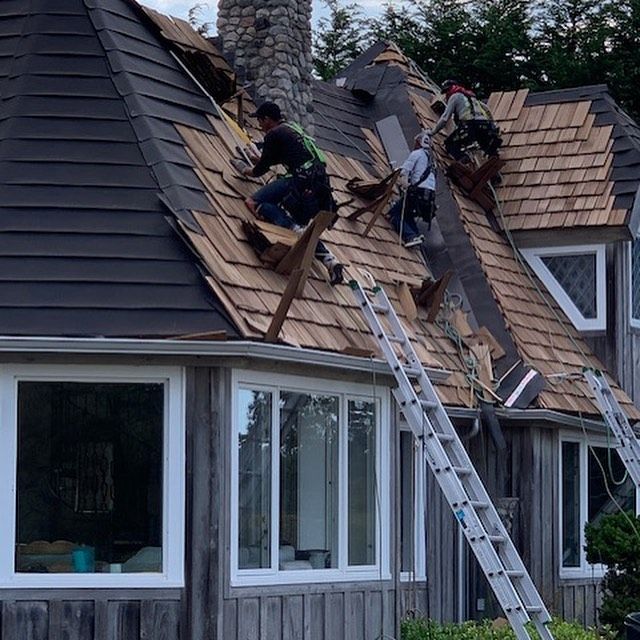 Two men are working on the roof of a house