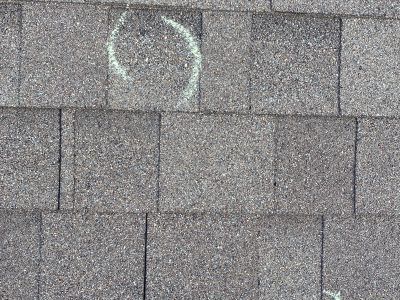 Gray shingle roof with a faded white circular marking near the top center