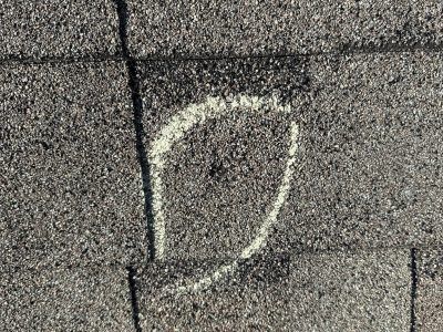 White chalk letter D on gray pavement beside a black line.