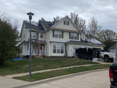 Suburban two-story house with garage and truck in the driveway on an overcast day