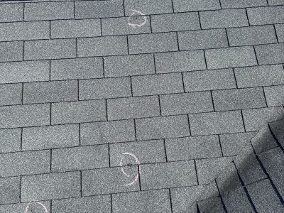 Gray shingled roof with white chalk markings and a dark shadow at the right edge
