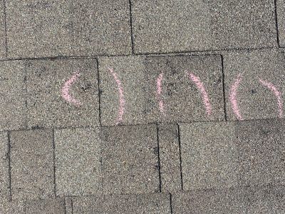 Pink chalk writing on gray brick pavement, partially visible and incomplete.