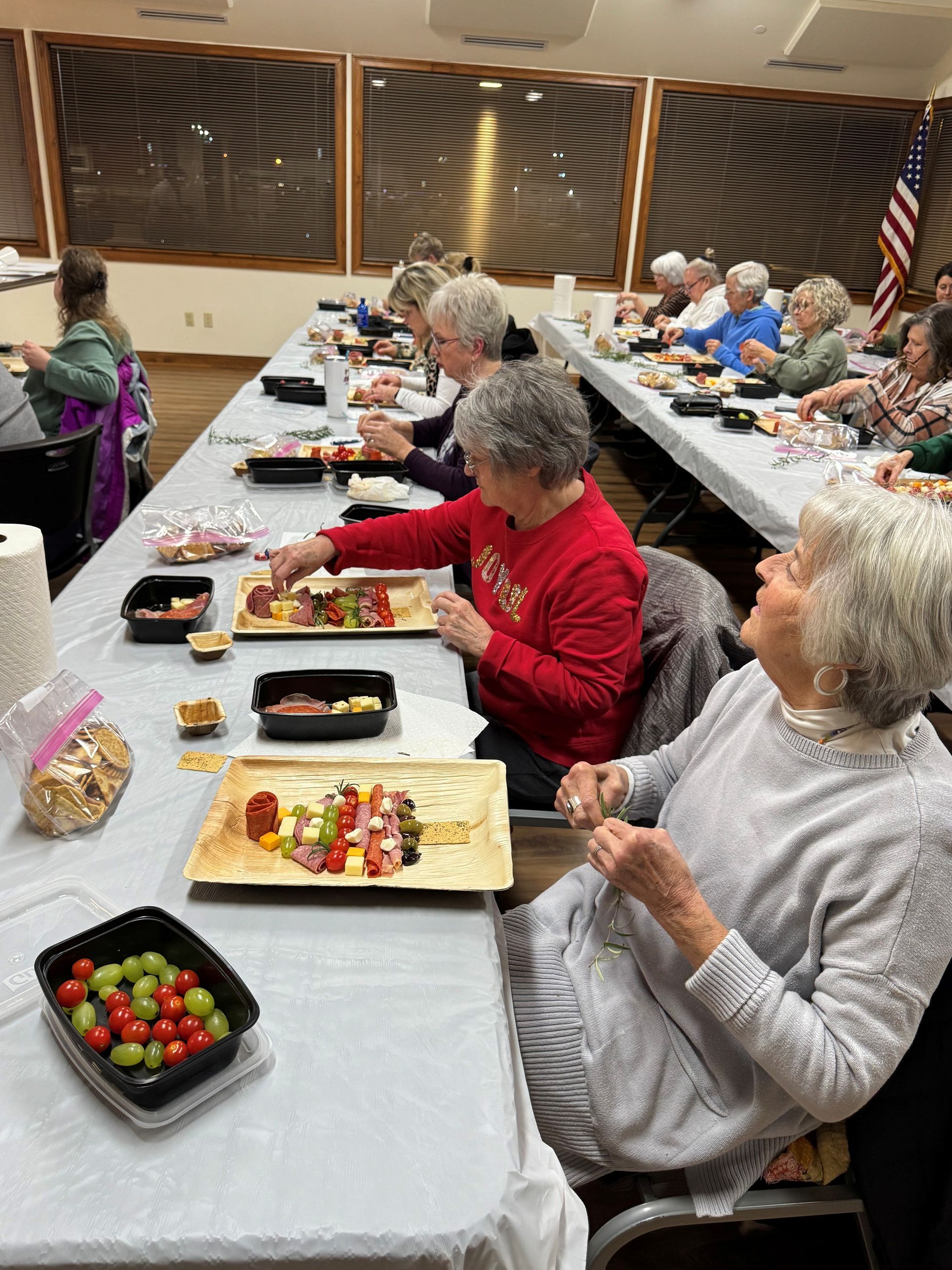 People seated at long tables sharing a meal in a community hall