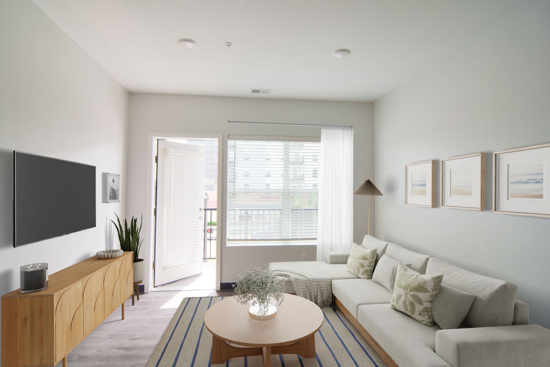 Pet-Friendly Affordable Apartments in Downtown Lincoln, NE - Union at Antelope Valley - Living Room With A White Sectional Sofa, Round Coffee Table, and Large Window.