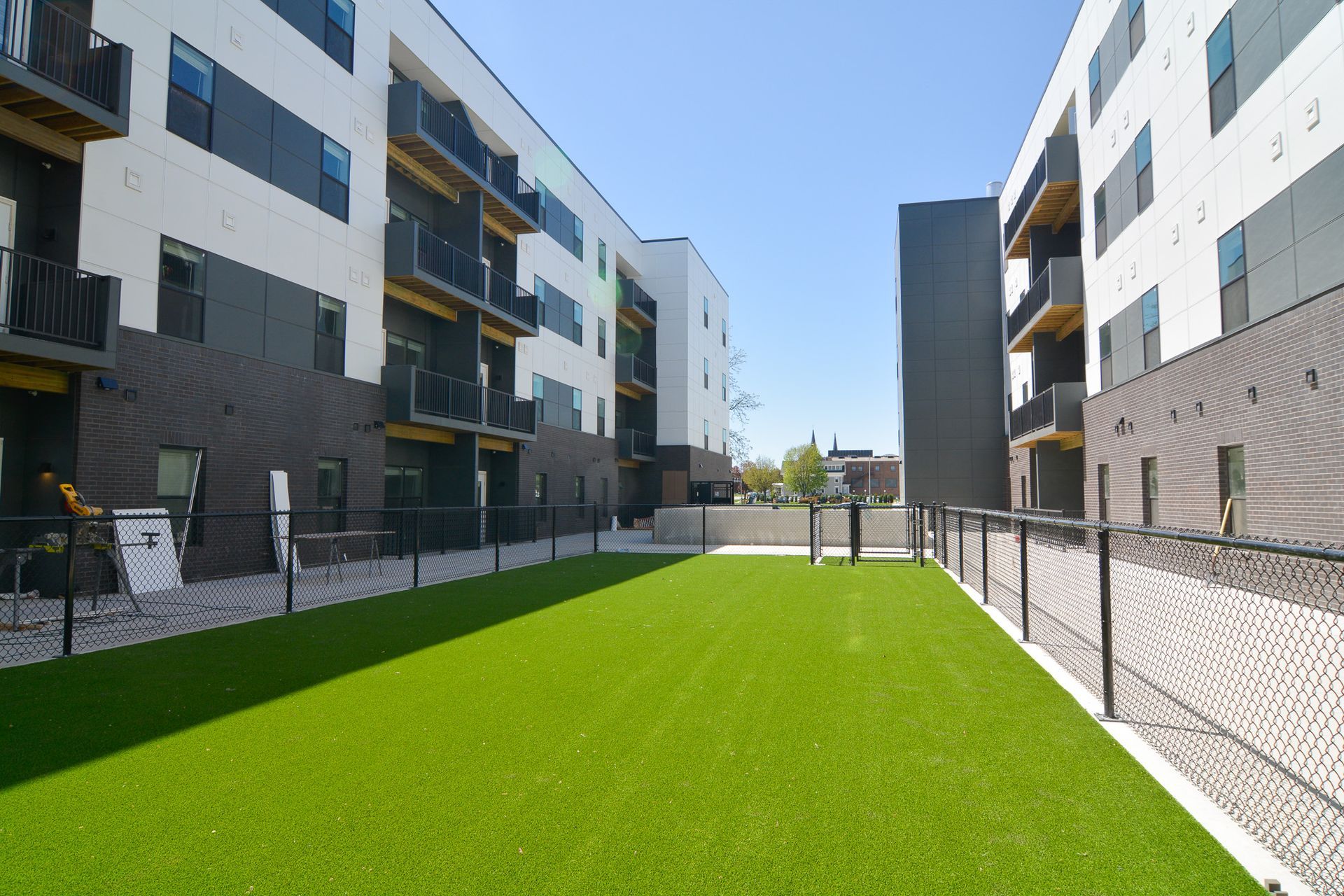 Dog-Friendly Affordable Apartments in Downtown Lincoln, NE - Union at Antelope Valley - Dog Park With Bright Green Turf, Fenced, Private Balconies, and Walkways.