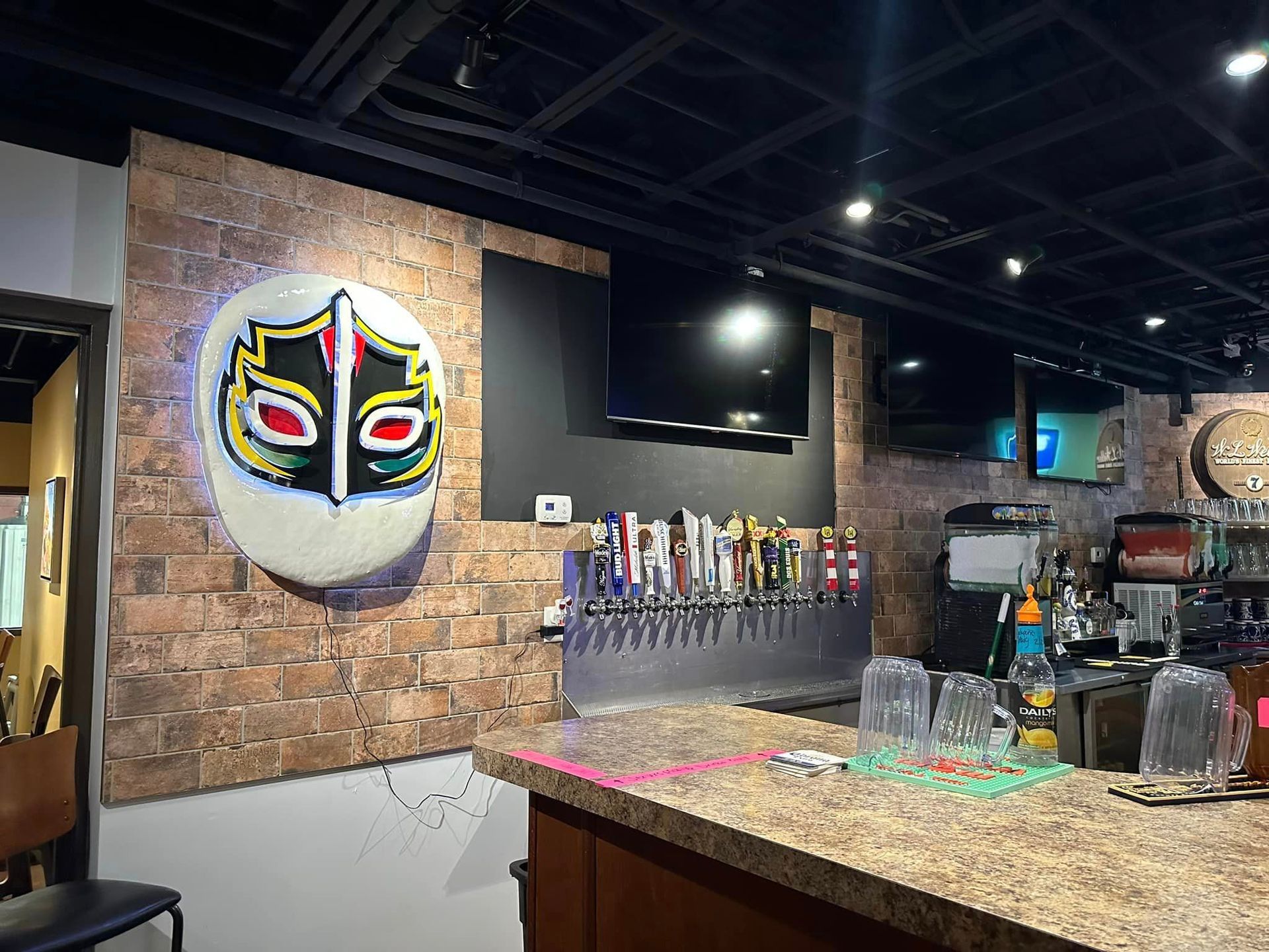 A bar with a painting of a mask on the wall