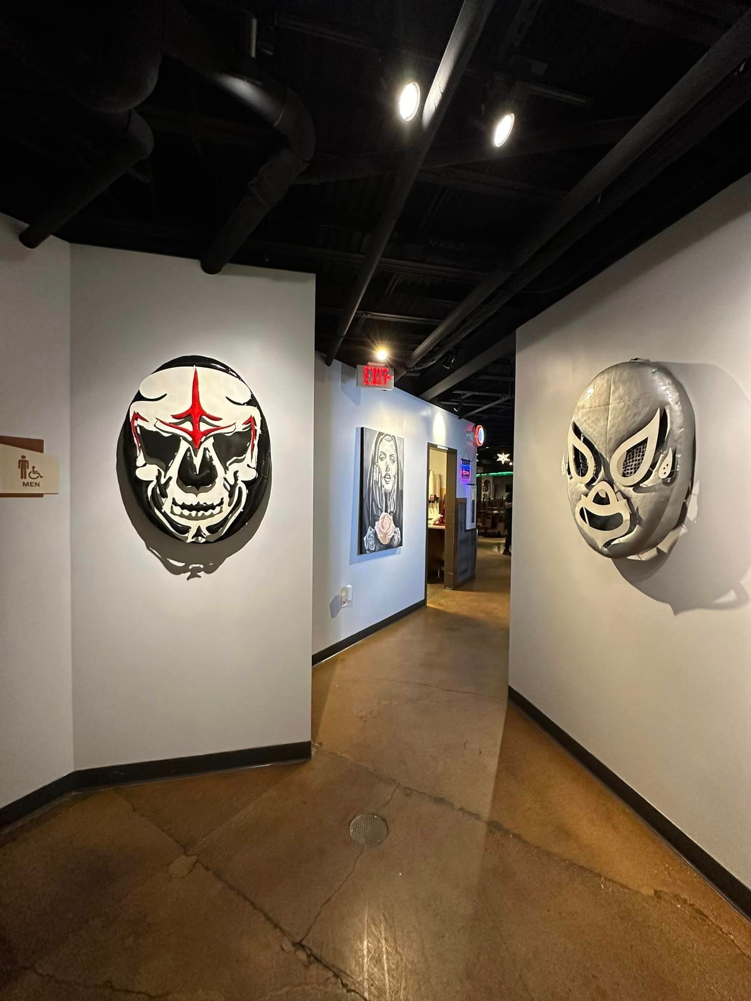 A hallway with a skull and a mask on the wall