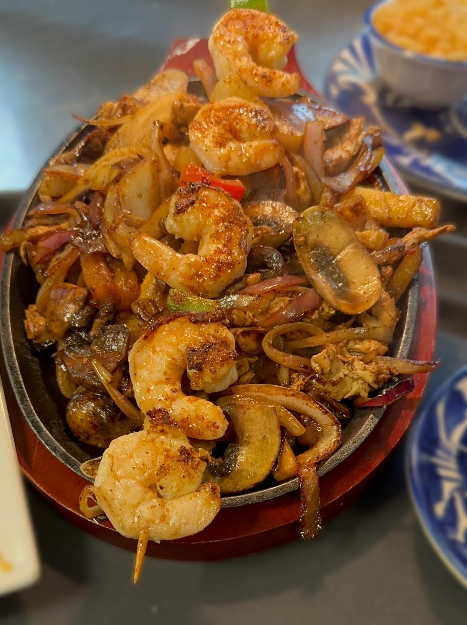 A tray filled with plates of food and bowls of rice on a table