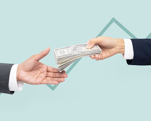 a man is handing a stack of money to another man .