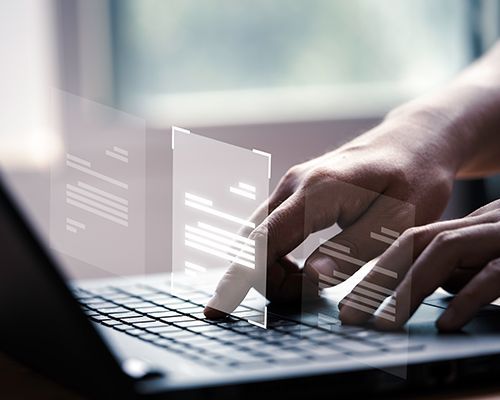 a person is typing on a laptop computer .