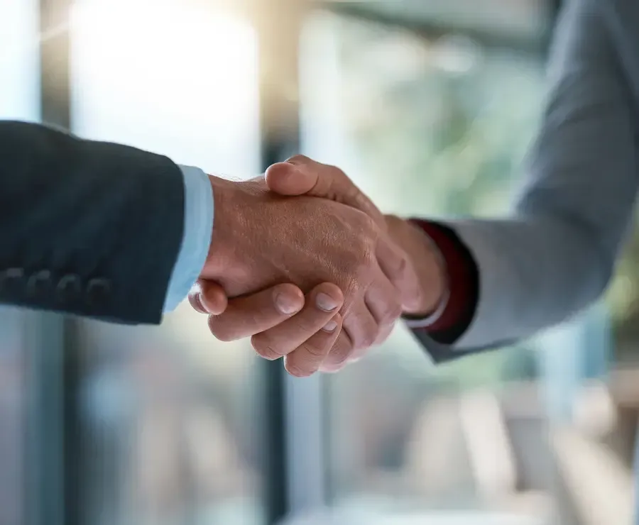 Businessmen shaking hands after making a deal in the office.