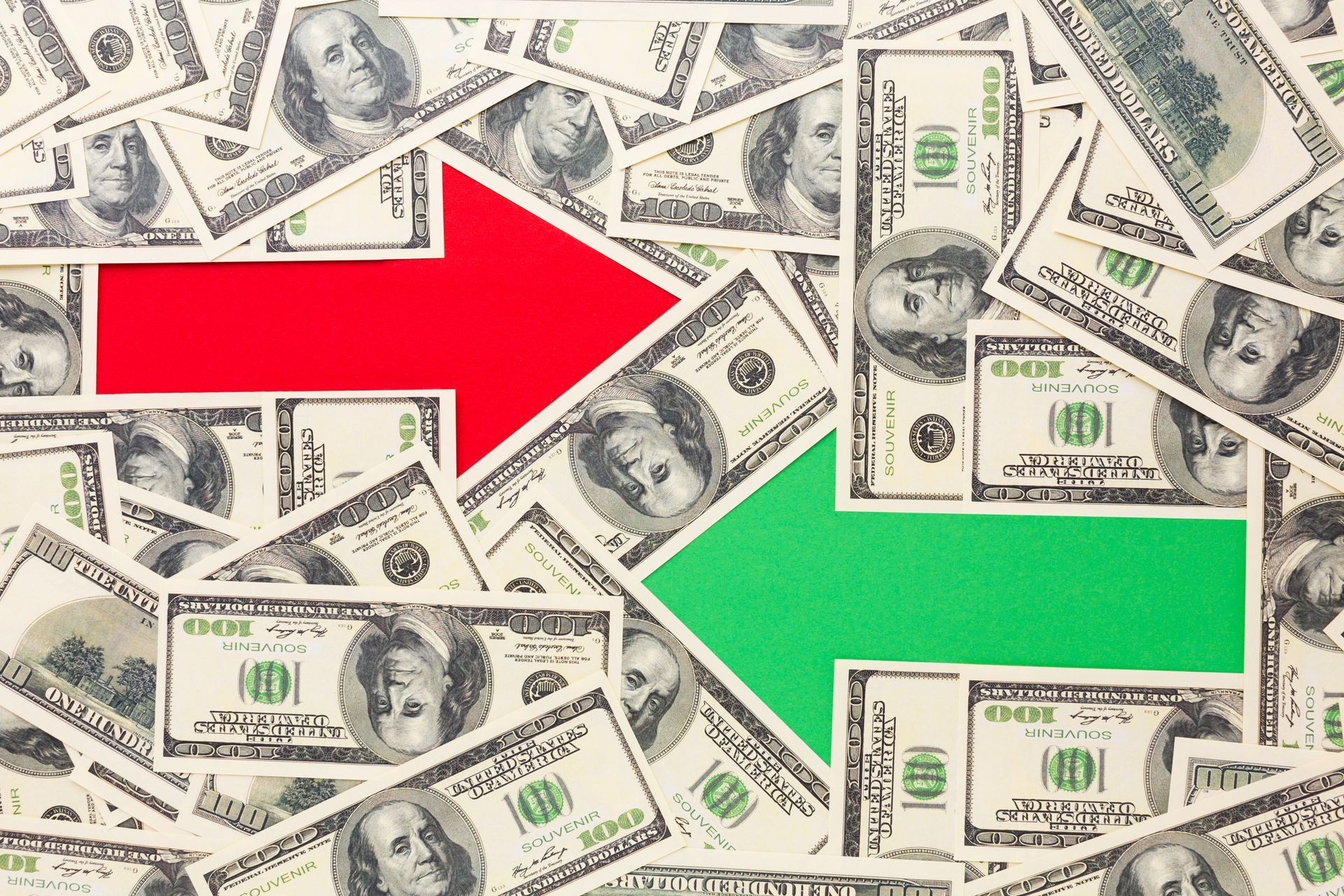 A pile of money with a red arrow pointing up.