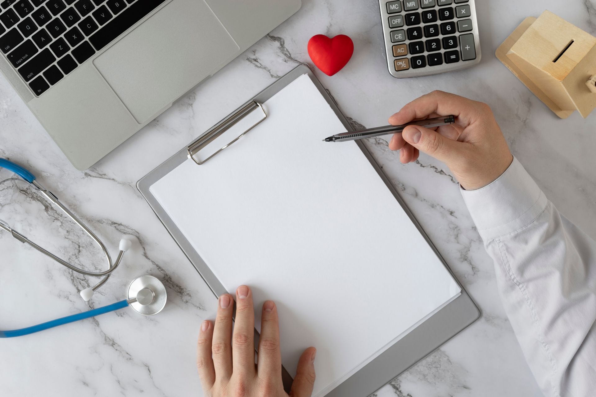 A person is holding a pen over a clipboard.