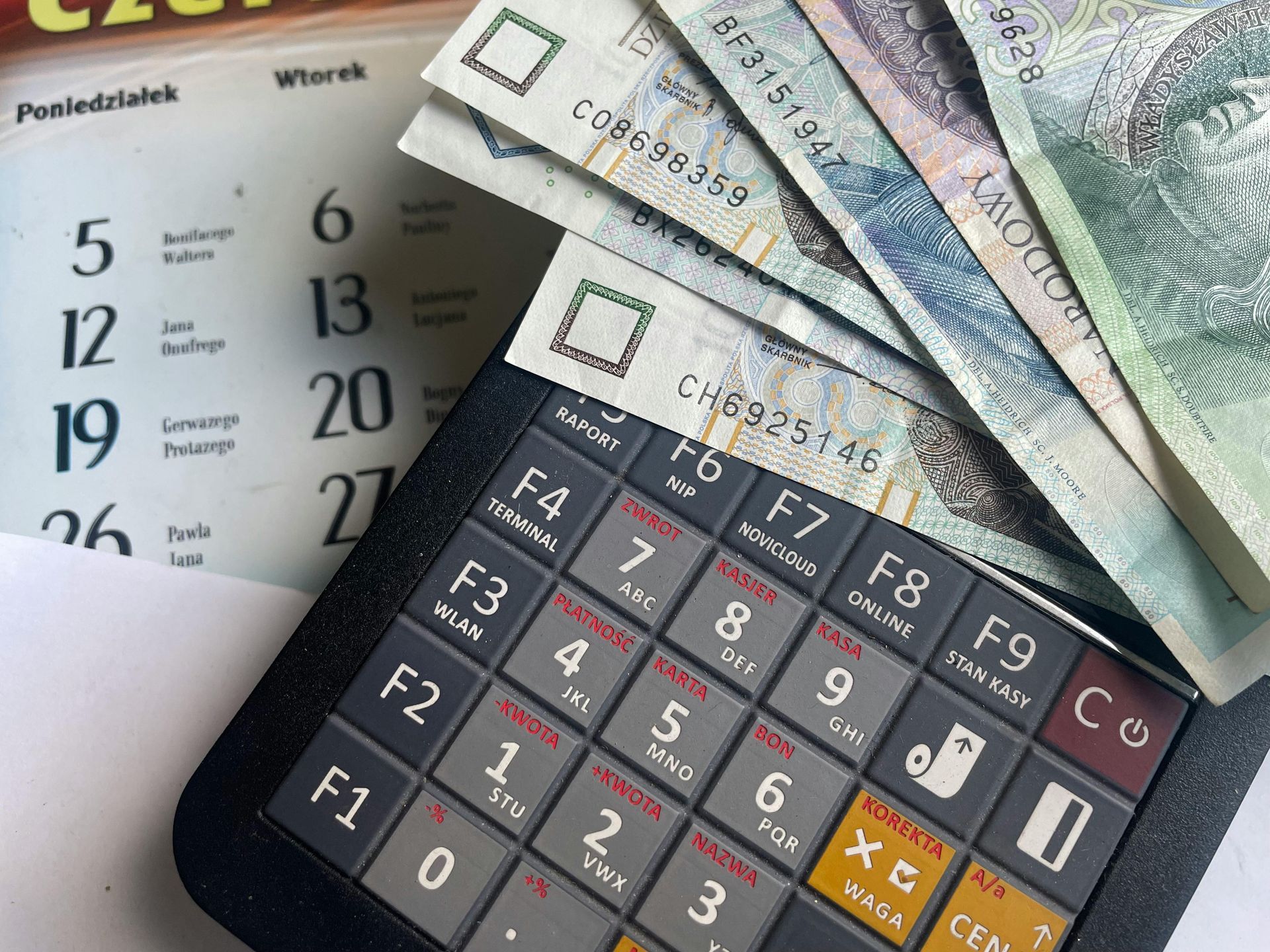Calculator with currency bills and a calendar, suggesting budgeting or financial planning