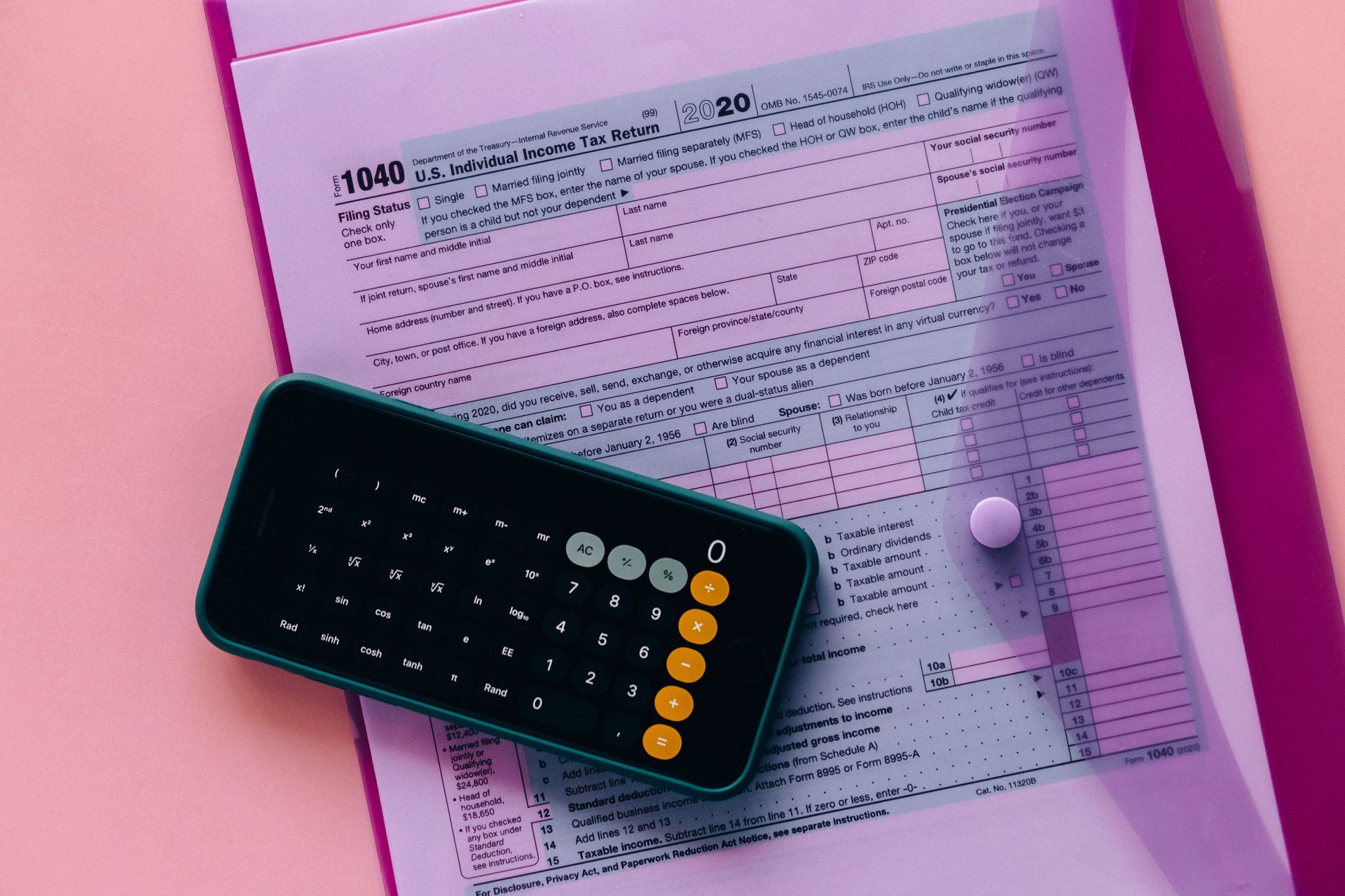 Black calculator on pink documents in a pink folder