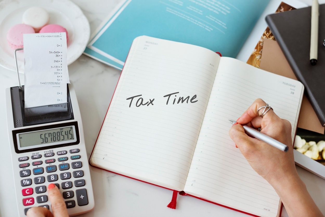 A person is writing in a notebook about tax time