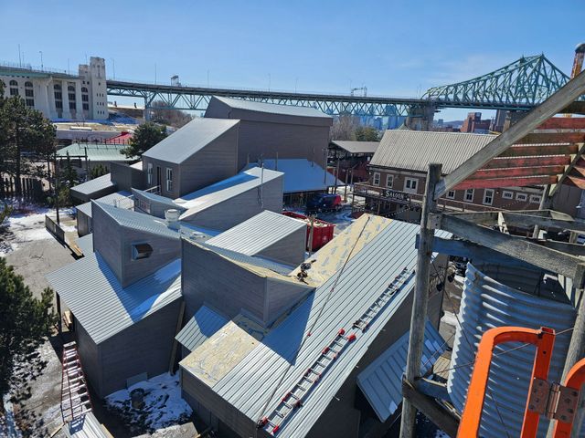 Une vue aérienne d'un bâtiment en construction avec un pont en arrière-plan.