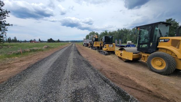 A group of construction vehicles are working on a road.