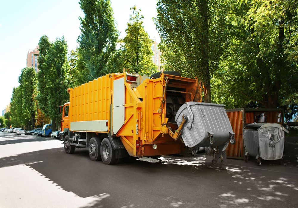 A Yellow Garbage Truck Is Parked On The Side Of The Road — Green Solutions Qld in Mulara, QLD