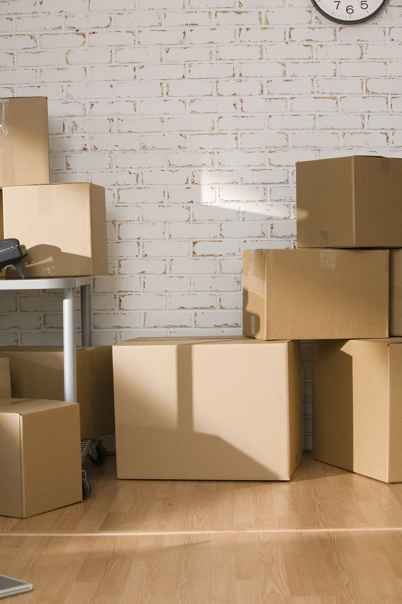 Una habitación llena de cajas de cartón y un reloj en la pared