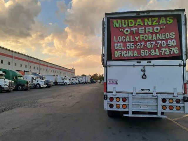Una camioneta blanca con un cartel en la parte de atras que dice mudanzas otero