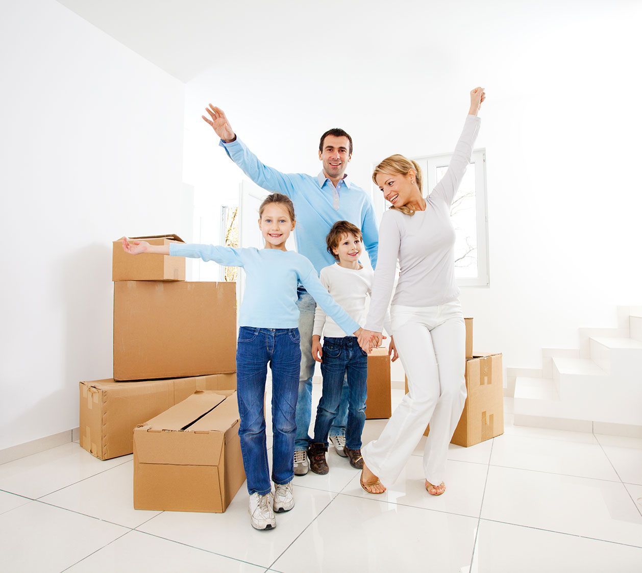 Una familia está parada en una habitación con cajas de cartón.