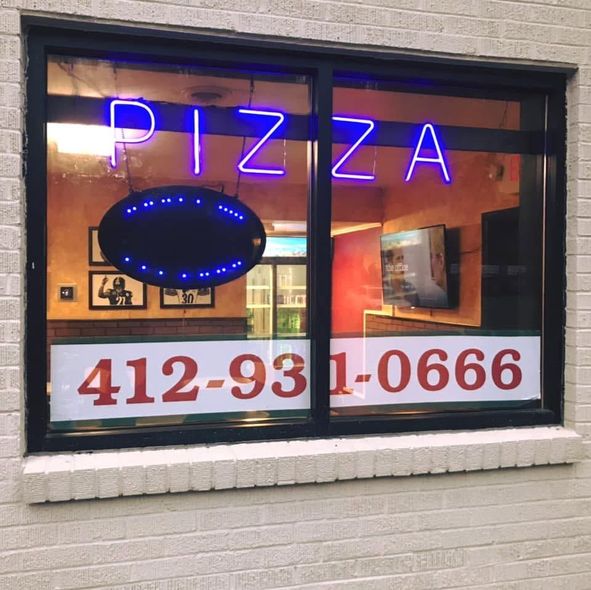 Pizza shop window with neon sign and phone number 412-931-0666