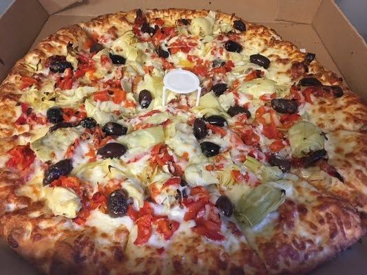 Large pizza in a cardboard box with olives, peppers, onions, cheese, and tomato sauce